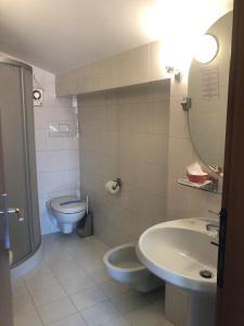 阿科索尔假日酒店的一间带水槽、卫生间和镜子的浴室