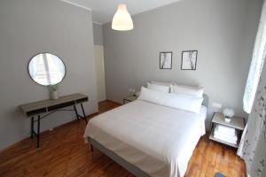科扎尼Newly Renovated Central 2 Bedroom Apartment in Kozani的卧室配有白色的床和镜子