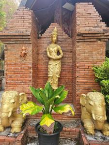清迈Phu Jaya Floresta Resort by ALPHATEL的砖墙,有神像