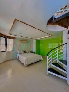巴拿马城Hostal Panama Experience的一间带绿色墙壁、一张床和楼梯的卧室