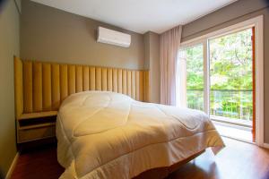 卡内拉Mountain Village - My Home Temporada的卧室配有白色的床和窗户。