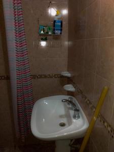 里奥夸尔托LA TRANQUERA DPTOs的浴室设有白色水槽和淋浴帘