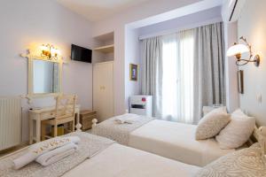 纳克索乔拉凯玛塔酒店的一间卧室设有两张床、一张桌子和一个窗口。