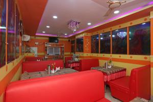 ĀsansolOYO Raj Rajeswari的一间餐厅,房间内设有红色的椅子和桌子