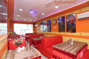 ĀsansolOYO Raj Rajeswari的一间餐厅,房间内设有红色的椅子和桌子