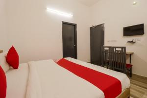 法里达巴德Perky Stay的卧室配有红色和白色的床和电视。