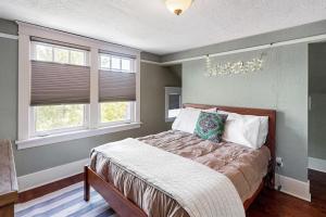西雅图West Woodland Wonder的一间卧室设有一张床和两个窗户。
