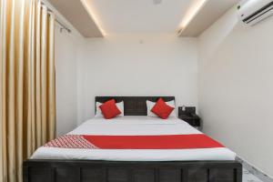 BijnaurHotel O Aastha Near Chaudhary Charan Singh International Airport的一间卧室配有红色枕头的床