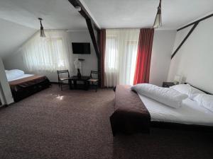 Şinca VecheBârlogul Urșilor的一间酒店客房,设有两张床和电视