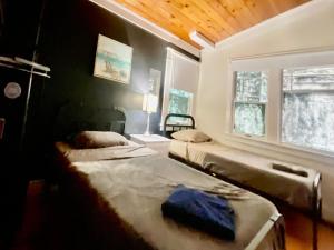 洛杉矶Venice Beach International Traveler Cabins & Suites- Surf & Yoga & E-Bike的一间卧室设有两张床和窗户。