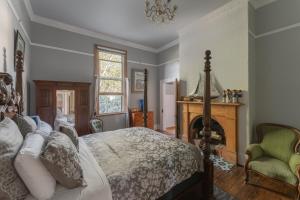 DerbyDerby Bank House- Heritage listed two bedroom old school B&B suite or a self contained cabin的一间卧室配有一张床和一个壁炉