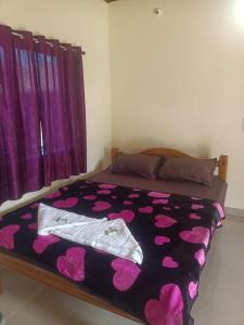 戈卡尔纳Niyam Beach Stay的一间卧室配有一张带紫色床罩的床