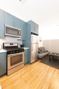联城Mins to NYC Captivating warm studio apt的厨房配有蓝色橱柜、炉灶和冰箱。