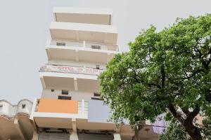 BihtaOYO Hotel Sri Hari的前面有一棵树的高楼