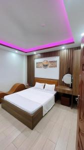 Na Dao TổngCường Thịnh Hotel的一间卧室设有一张粉红色天花板的大床