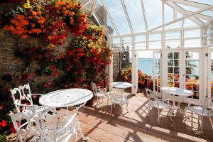 圣欧班潘拉玛旅馆的温室里带桌椅和鲜花的庭院