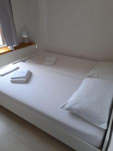 帕格Hostel Jadran的一张白色的床,上面有两条毛巾