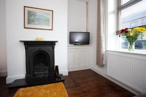 沃利Spacious 3 bedroom Cottage in Whalley的客厅设有壁炉和电视。
