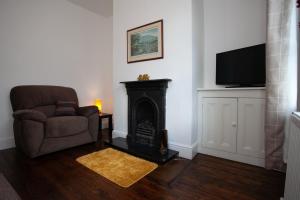 沃利Spacious 3 bedroom Cottage in Whalley的客厅配有椅子和壁炉