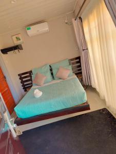MpongweBukari Executive Lodge的一间卧室配有一张带蓝色床单和粉红色枕头的床。
