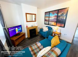 ArlecdonBlakefell by Prestige Properties SA的客厅配有蓝色的沙发和电视