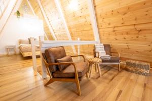 科斯比Valhalla Cabins AFrames with hot tubs的木墙、两把椅子和一张桌子