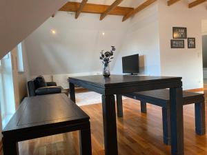 EllerauEllerau Home的一间带木桌和电视的用餐室