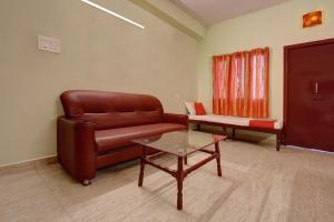 马杜赖OYO Hotel Radhakrishna的客厅配有真皮沙发和桌子