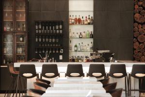 萨凡纳萨凡纳历史区江山旅馆&套房酒店的酒吧配有椅子和带葡萄酒瓶的吧台