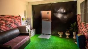 雅温得Appartement lumineux et paisible près centre Yaoundé的客厅设有绿色地板和冰箱