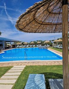 阿尔米罗斯海滩Villa Pami的享有带稻草伞的游泳池的景色