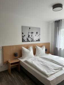巴特洪内夫Pension im Wirtshaus Himberg的卧室配有一张带白色床单和枕头的大床。
