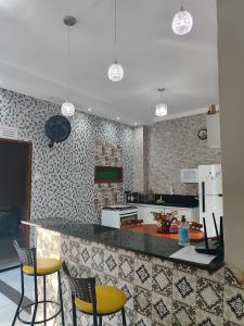 阿拉卡茹Casa confortável com piscina compartilhada的厨房配有黄色椅子和台面