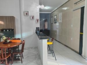 阿拉卡茹Casa confortável com piscina compartilhada的厨房以及带桌椅的用餐室。