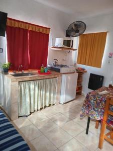普洛缇尔DORMI-con HIDROMASAJE- POSADA RUTA 22 totalmente EQUIPADO的厨房配有水槽和红色窗帘