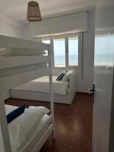 蓬塔翁布里亚Alta Vista Punta Umbría的一间卧室设有两张双层床和一扇窗户。