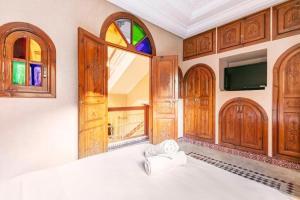 马拉喀什16 Riads的一间卧室设有一张带窗户的床和一台电视。