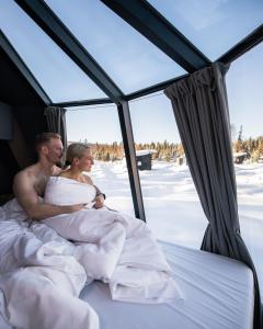 罗瓦涅米Nova Galaxy Village的一位新娘和新郎躺在雪地里的床上