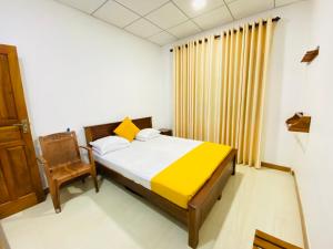 AmbagamuwaCarmel Hill Resort的一间卧室配有一张床和一把椅子