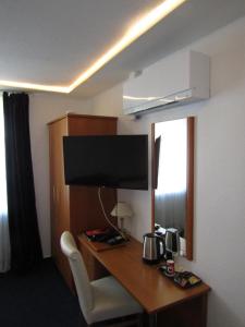 赖讷莱茵河-奥特斯塔德特德酒店的酒店客房设有一张书桌,电视