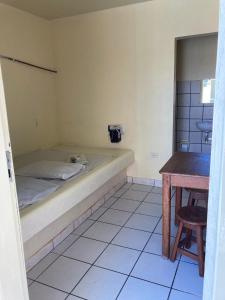 马塞约Pousada Caliente的小房间设有一张床和一张桌子