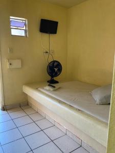 马塞约Pousada Caliente的客房设有带风扇和电视的床。