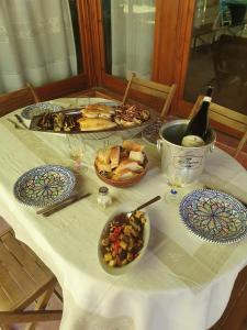 蒙德罗La Casetta del Melograno的餐桌,带食物盘和一瓶葡萄酒