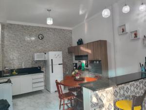 阿拉卡茹Pousada Bem-te-vi的厨房配有桌子和白色冰箱。