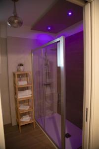 塔兰托Lux Suite的浴室内带紫色照明的淋浴
