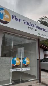 乌巴图巴Pousada Mar Suites Toninhas的人面和家具的标志