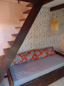 伊塔帕里卡Casa Girassol的一张位于带沙发楼梯的房间的床铺
