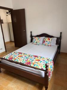 乌巴图巴Pousada Mar Suites Toninhas的一间卧室配有一张木架床