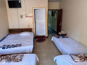 吉布提Addis Guest House Djibouti的一间设有两张床的房间和一个通往房间的门