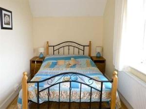 BallymoteThe Gardener's Cottage的一间卧室配有一张带蓝色棉被的床